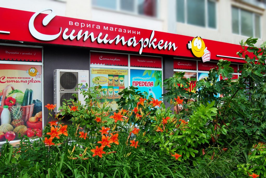 Табелата и витрините на Ситимаркет „Китайска стена“ на бул. „8-ми Приморски полк“ 135 във Варна, с цветя пред магазина
