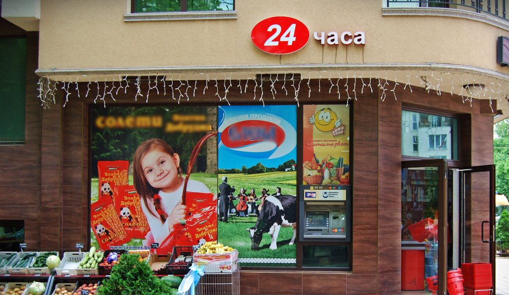 Входът на Ситимаркет „Зеленика“ на ул. „Зеленика“ 2 във Варна: табелата „24 часа“ и щандът с плодове и зеленчуци пред витрината